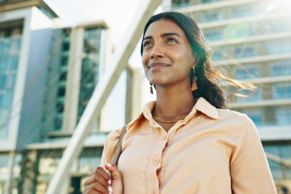 A confident businesswoman looking forward in reflection during her commute in the city.