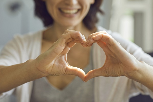 Older woman holding hands in a heart shape
