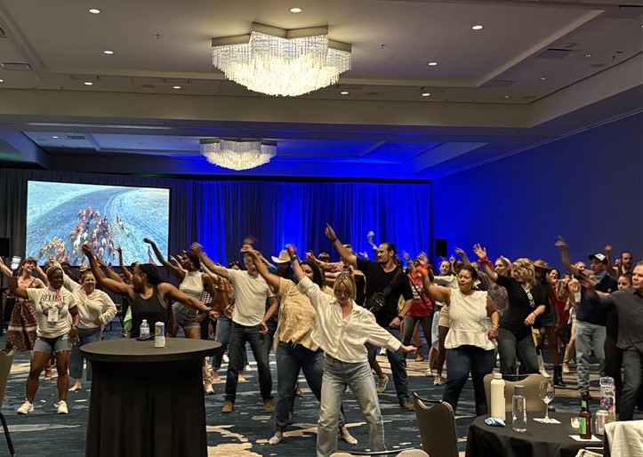 Annual Wellness Summit attendees enjoy line dancing together.