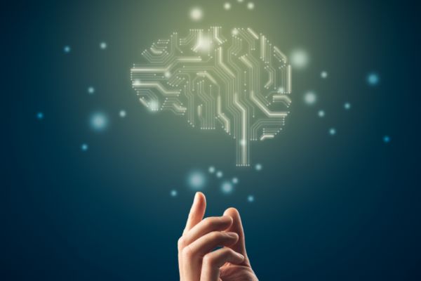 Hand gesturing towards a generated image of a brain made of computer wiring.