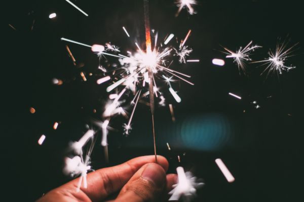 Hand holding a lit sparkler in the night