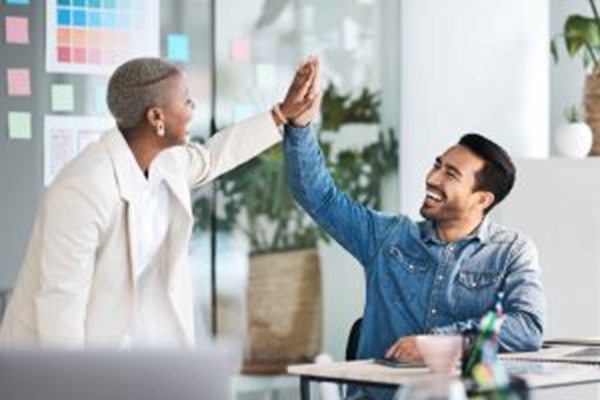 Two colleagues smiling and high-fiving