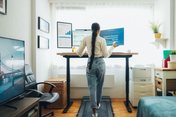 Woman working at standing desk while walking at treadmill