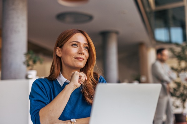 A portrait of a pensive woman sitting at a desk in the office