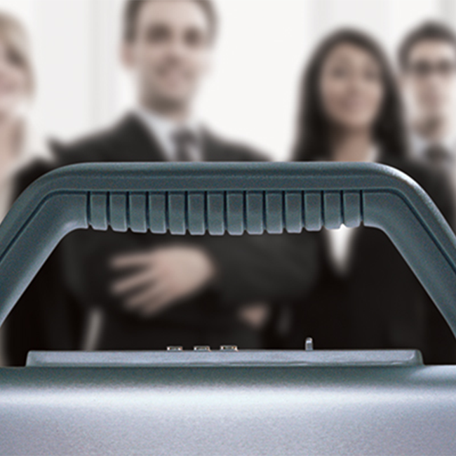 A closeup of a briefcase handle with businesspeople in the distance