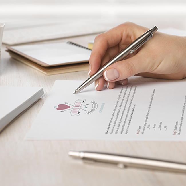 A closeup of a hand holding a pen, about to write on a sheet of paper