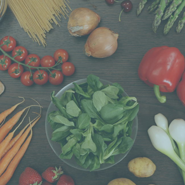 Overhead image of a salad in a bowl surrounded by fruits and vegetables