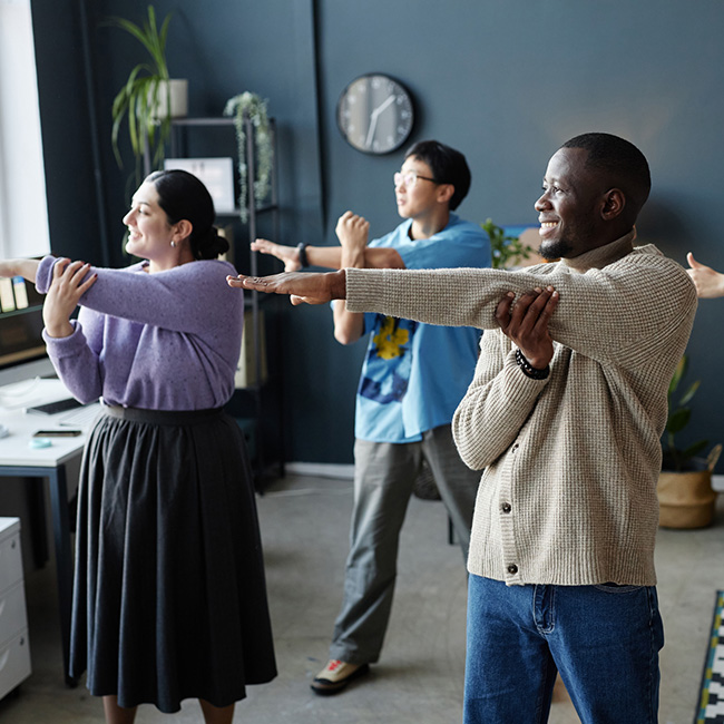 Group of people doing stretching exercises in an office